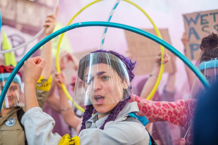 A young woman wearing a protective visor on a protest march.