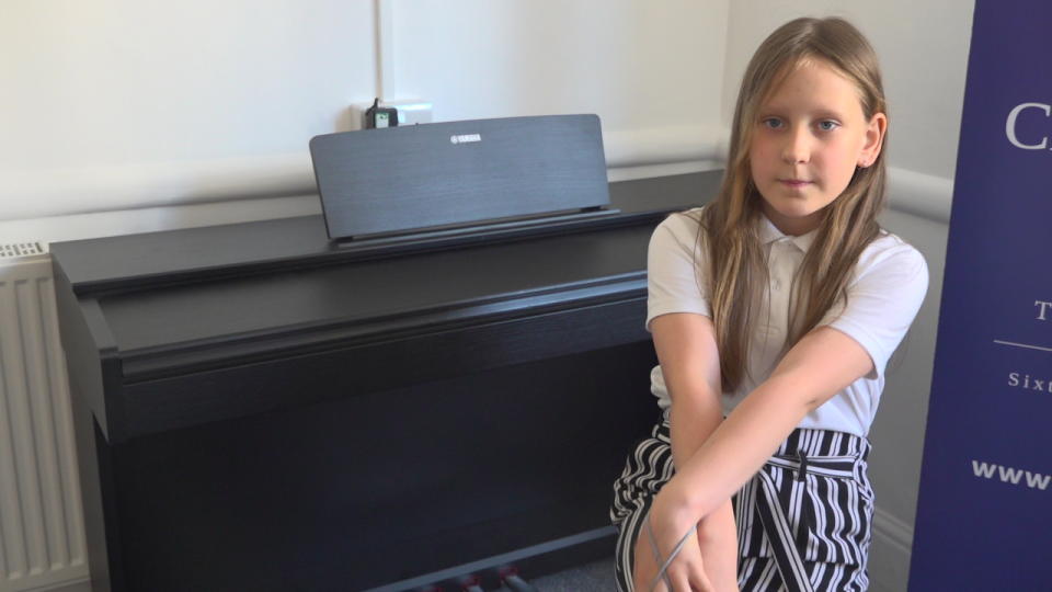 Girl sitting on a chair with her hands crossed over her leg