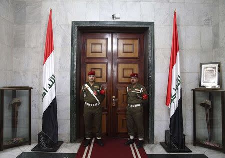 Iraqi guards stand in front of a door inside the Ministry of Defence during a visit from U.S. Secretary of Defense Chuck Hagel, in Baghdad December 9, 2014. U.S. Defense Secretary Chuck Hagel arrived in Baghdad on Tuesday as the United States expands its presence and touts progress against Islamic State militants four months after starting a campaign of air strikes in Iraq. REUTERS/Mark Wilson/Pool (IRAQ - Tags: POLITICS MILITARY)