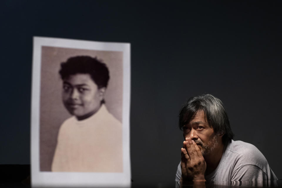 Mark Apuron, 45, sits beside a photo of himself when he was 15 years old, the age when he says he was raped by his uncle, former Archbishop Anthony Apuron at the rectory, in Hagatna, Guam, Monday, May 13, 2019. "Everything happened so fast," he recalls. "But that one second, for me, it never stops." He never found the right words to tell his parents what happened. "I didn't think I would be believed," he said, tearing up. "I thought I was the only one." Anthony Apuron denies the allegations, which are detailed in a lawsuit. (AP Photo/David Goldman)