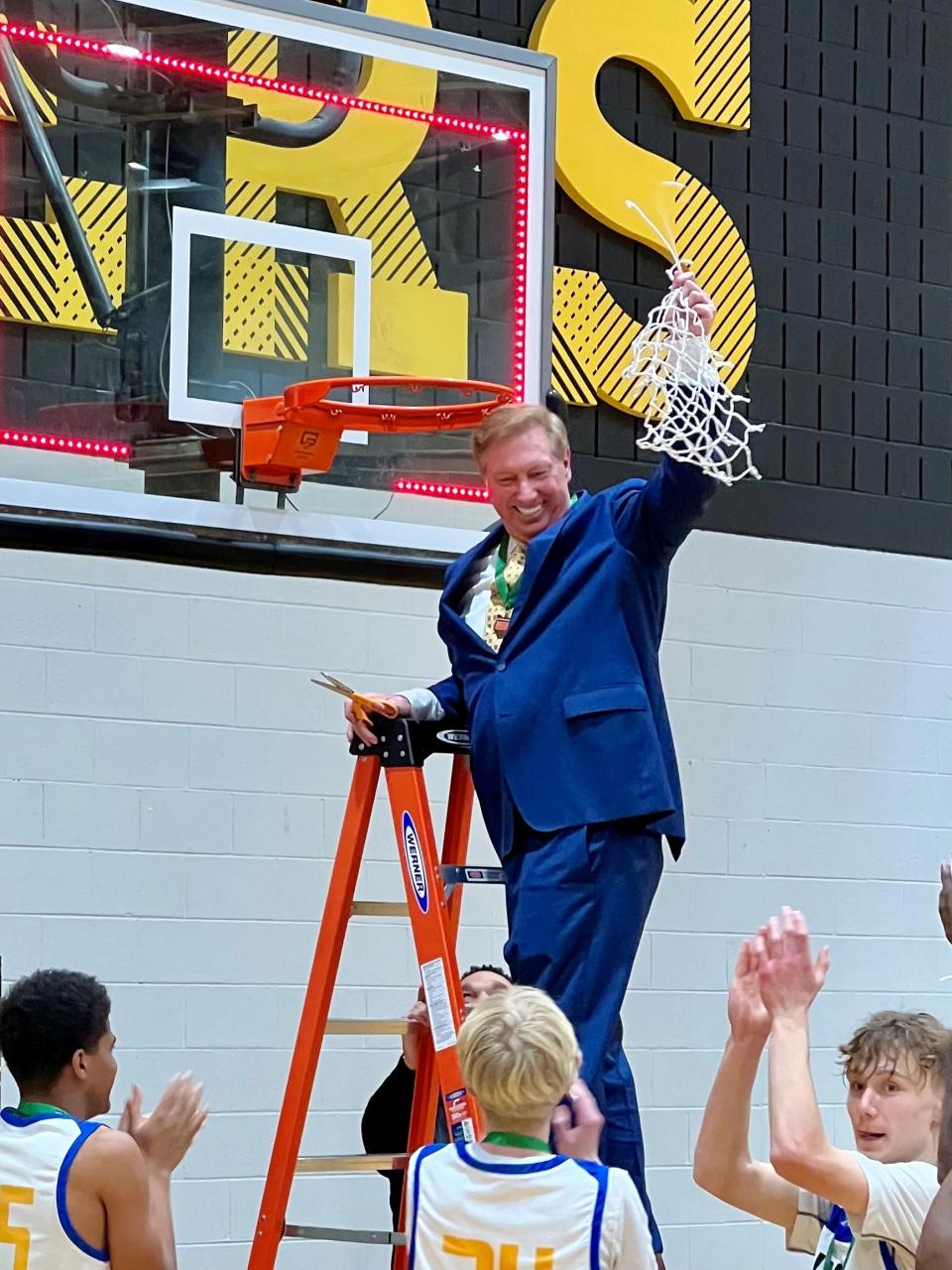 Northside Christian head coach Tim Kusan cuts down the net after Friday's Division IV boys basketball district championship game at Ohio Dominican.