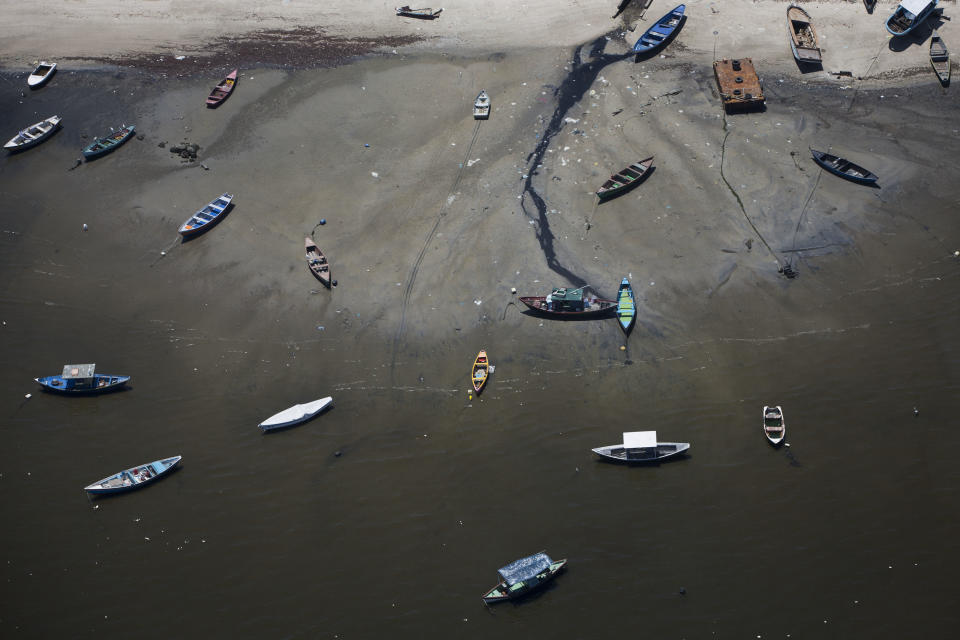 In this Nov. 19, 2013 photo small boats sit on the shore of Guanabara Bay in the suburb of Sao Goncalo, across the bay from Rio de Janeiro, Brazil. Rio dumps almost 70 percent of its untreated sewage into its surrounding waters, which fouls the bay with human waste and floating debris. (AP Photo/Felipe Dana)