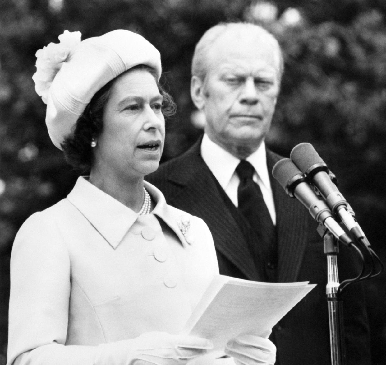 Queen Elizabeth II at the microphone, as President Gerald Ford listens.