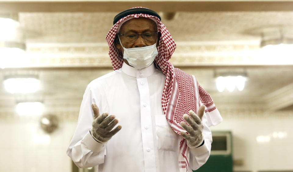 A Saudi worshipper wearing a face mask and gloves as he prays dawn prayers at al-Mirabi Mosque in Jiddah, Saudi Arabia, Sunday, May 31, 2020. The Ministry of Islamic Affairs said mosques will open to the public for prayers from May 31 until June 20, except in Mecca, with precautionary measures and instructions. (AP Photo/Amr Nabil)
