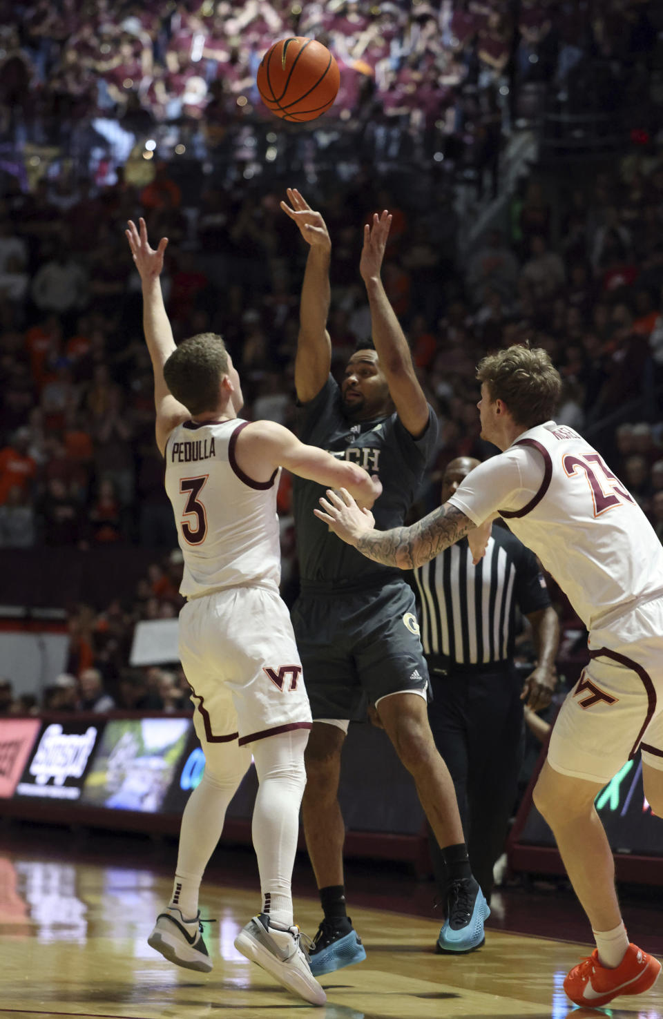 Georgia Tech's Kyle Sturdivant (1) shoots while defended by Virginia Tech's Sean Pedulla (3) and Tyler Nickel (23) in the first half of an NCAA college basketball game, Saturday, Jan. 27, 2024, in Blacksburg, Va. (Matt Gentry/The Roanoke Times via AP)