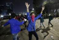 Student protesters shout slogan during a protest outside the parliament in Jakarta, Indonesia Tuesday, Sept. 24, 2019. Police fired tear gas and water cannons Tuesday to disperse thousands of rock-throwing students protesting a new law that they said has crippled Indonesia's anti-corruption agency.(AP Photo/Achmad Ibrahim)