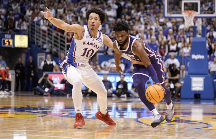 TCU guard Mike Miles Jr. (1) drives past Kansas forward Jalen Wilson (10) during the second half of an NCAA college basketball game on Saturday, Jan. 21, 2023, at Allen Fieldhouse in Lawrence, Kan. TCU defeated Kansas, 83-60. (AP Photo/Nick Krug)