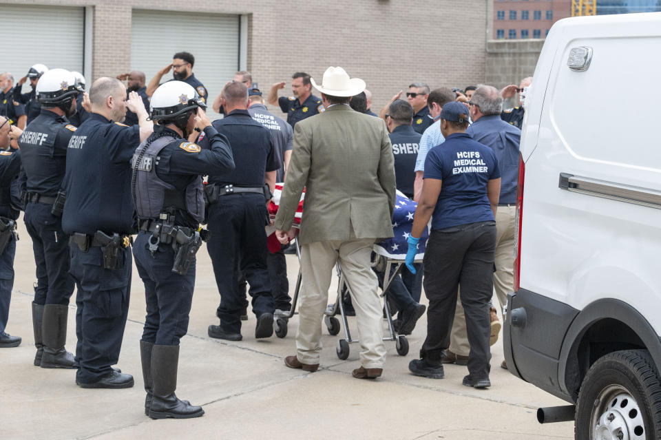 Harris County Sheriff's deputies stand as the body Deputy John Hampton Coddou is transported to the Harris County Institute of Forensic Sciences, Tuesday, April 23, 2024, in Houston. Coddou was struck by a vehicle while assisting at a crash scene on the Grand Parkway at Cumberland Ridge Drive on Tuesday morning, and was transported by Life Flight to Memorial Hermann Medical Center where he later died. (Kirk Sides/Houston Chronicle via AP)