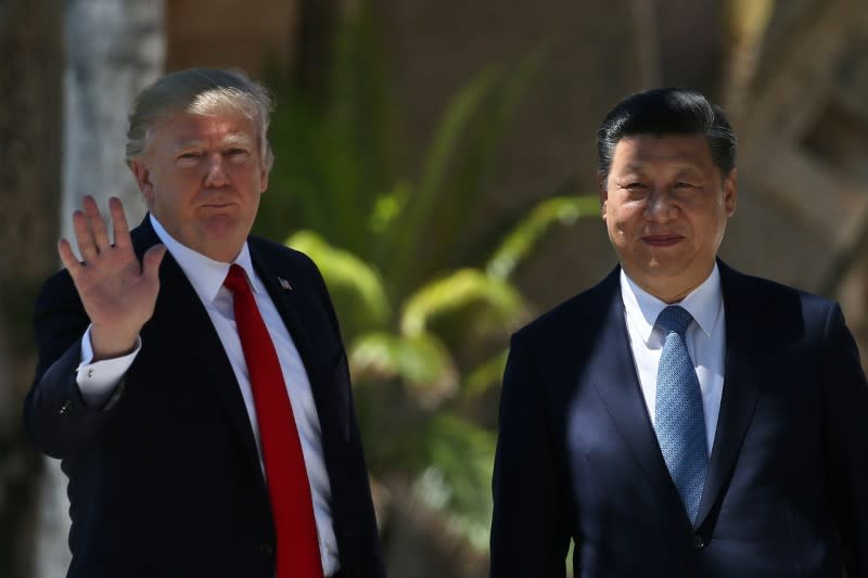 U.S. President Donald Trump waves as he and China's President Xi Jinping walk along the front patio of the Mar-a-Lago estate after a bilateral meeting in Palm Beach, Florida, U.S., April 7, 2017. REUTERS/Carlos Barria 