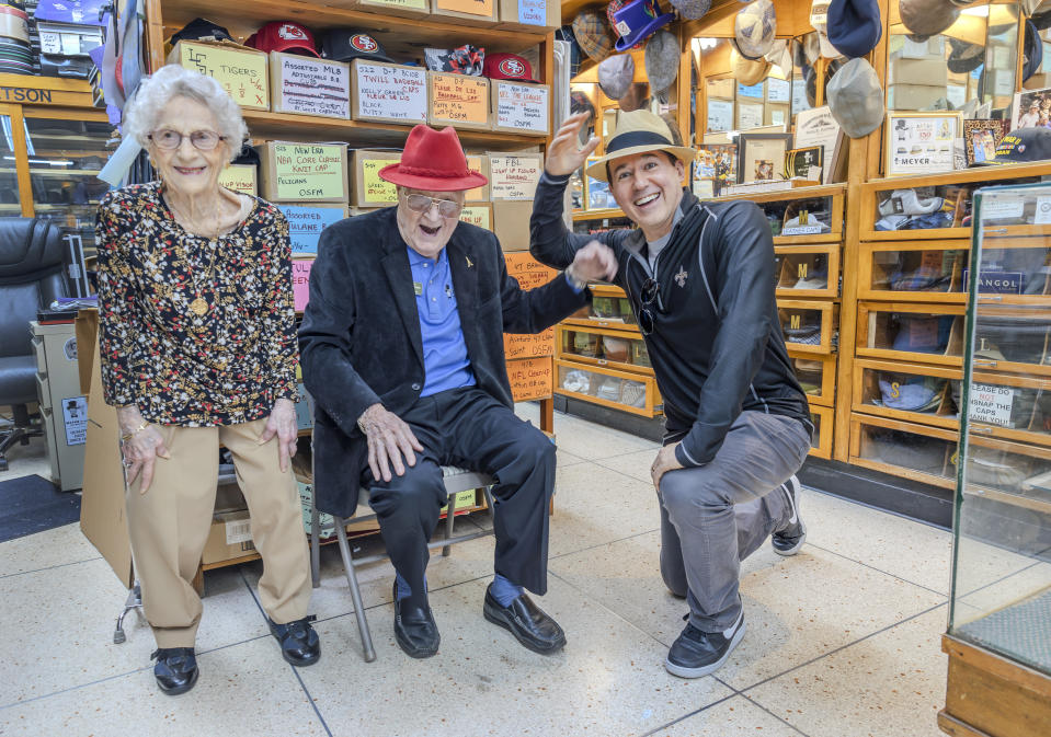 Sam Meyer and his wife, Marcelle, chat with Raymond Arroyo, right, who had just bought a hat at Meyer the Hatter in downtown New Orleans on Friday, Feb. 23, 2024. Meyer was awarded the rank of chevalier, or knight, of the National Order of the Legion of Honor. (Chris Granger/The Times-Picayune/The New Orleans Advocate via AP)