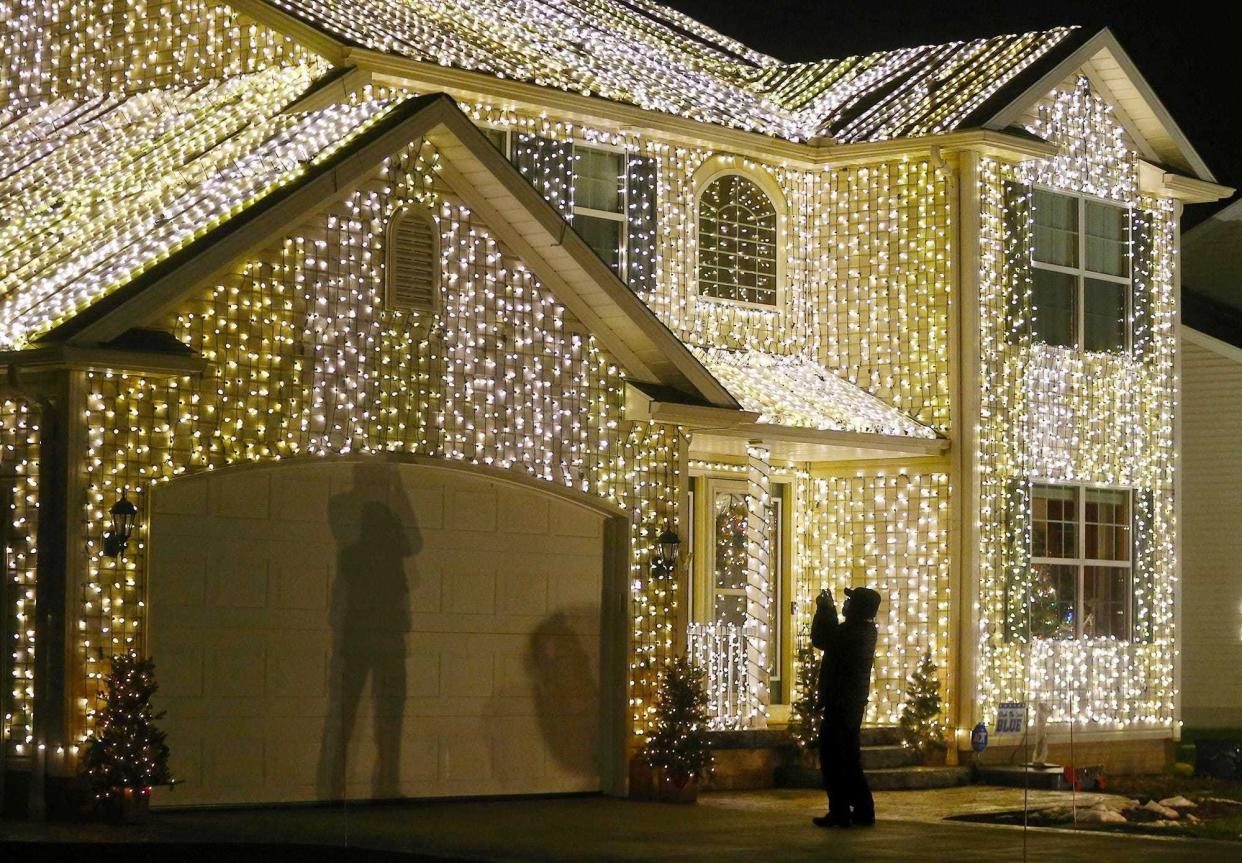 A visitor gets a close-up photo of some of the 25,000 Christmas lights on the front of the Osterland family's "Christmas Vacation" Griswold-themed home in Wadsworth.