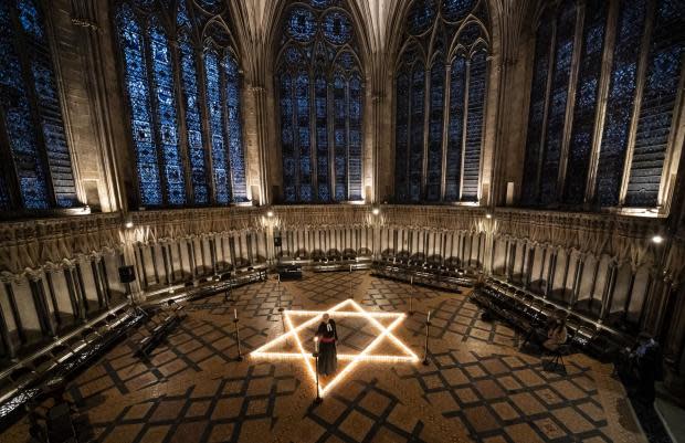 York Press: The Reverend Canon Michael Smith, Acting Dean of York, helps light six hundred candles in the shape of the Star of David, in the Chapter House at York Minster in York, to mark International Holocaust Day. Picture: PA