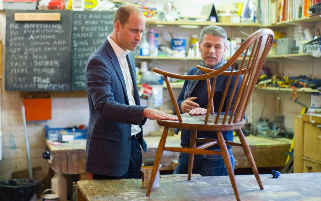 Prince William, Duke of Cambridge, talks with volunteer Bernard Bristow, during his visit to the Spitalfields Crypt Trust - AFP