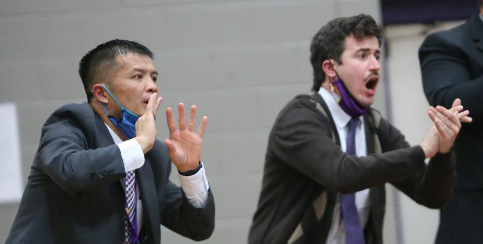 North Henderson head wrestling coach Heang Uy, left, and assistant Wayne Nock coach from the sidelines during a tri-match with Enka and West Lincoln earlier this season at North.