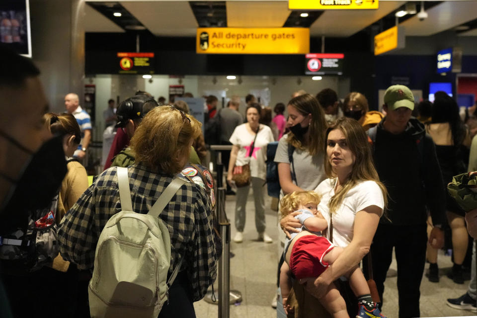 FILE - Travellers queue at security at Heathrow Airport in London, Wednesday, June 22, 2022. After two years of pandemic restrictions, travel demand is back with a vengeance but airlines and airports that slashed jobs during the depths of the COVID-19 crisis are struggling to keep up. With the busy summer tourism season underway in Europe, passengers are encountering chaotic scenes at airports, including lengthy delays, canceled flights and headaches over lost luggage. (AP Photo/Frank Augstein, File)