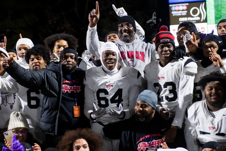 Aliquippa head coach Mike Warfield (back, center) poses for a group photo with his team after winning the PIAA Class 4A football championship game against Dallas at Cumberland Valley High School, Thursday, Dec. 7, 2023, in Mechanicsburg, Pa. The Quips won their fifth state title, 60-14.