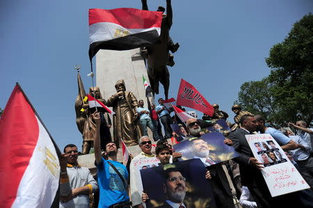 Pro-Islamist demonstrators hold Egyptian flags and posters of former President Mohamed Mursi during a protest in support of him at the courtyard of Fatih mosque in Istanbul, Turkey, May 17, 2015. REUTERS/Yagiz Karahan