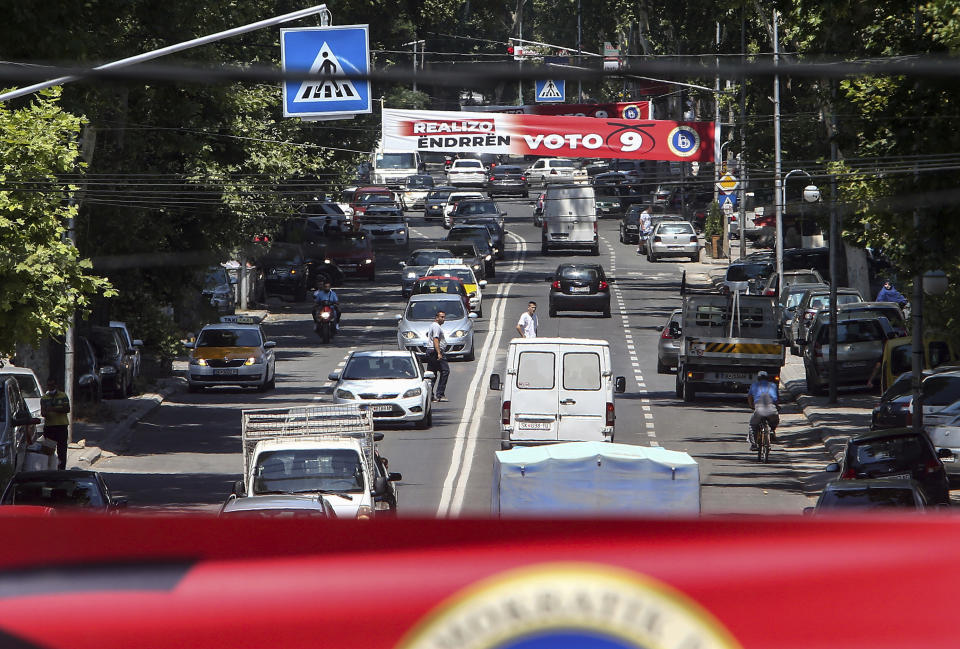 Electoral campaign banners of the largest ethnic Albanian party Democratic Union for Integrations (DUI) are placed above a busy a street in Skopje, North Macedonia on Saturday, July 11, 2020. North Macedonia holds its first parliamentary election under its new country name this week, with voters heading to the polls during an alarming spike of coronavirus cases in the small Balkan nation. (AP Photo/Boris Grdanoski)