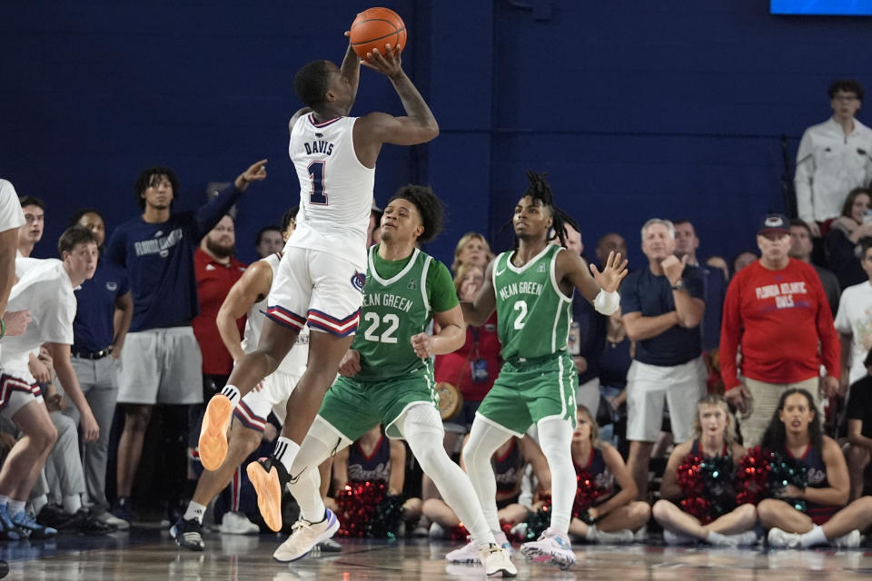 Florida Atlantic guard Johnell Davis (1) goes up for the winning shot against North Texas guards CJ Noland (22) and Jason Edwards (2) during the final seconds of the second half of an NCAA college basketball game, Sunday, Jan. 28, 2024, in Boca Raton, Fla. (AP Photo/Wilfredo Lee)