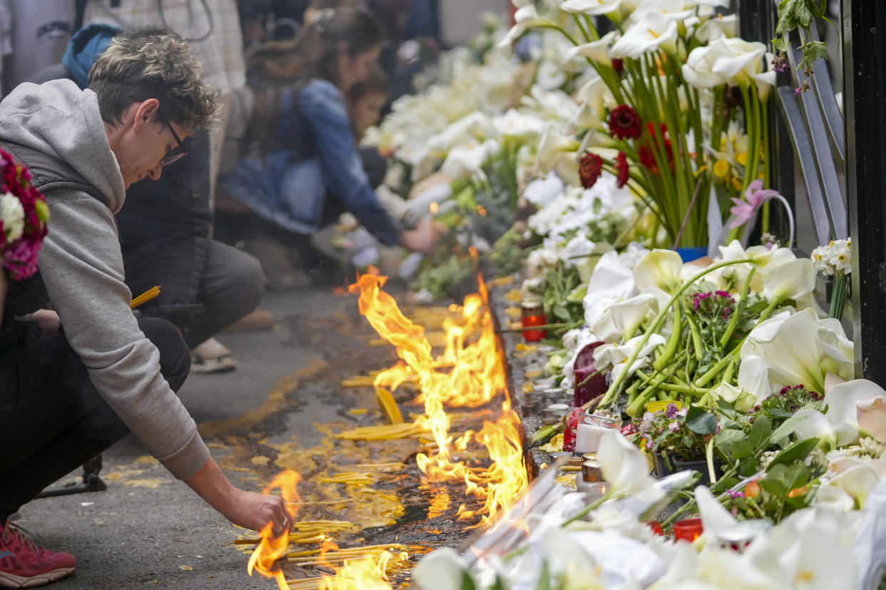 People light candles for the victims in front of the Vladimir Ribnikar school in Belgrade, Serbia, Thursday, May 4, 2023. A 13-year-old opened fire Wednesday at his school in Serbia's capital. He killed eight fellow students and a guard before calling the police and being arrested. Six children and a teacher were also hospitalized. (AP Photo/Darko Vojinovic)