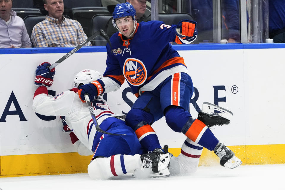 New York Islanders' Adam Pelech (3) checks Montreal Canadiens' Justin Barron (52) during the first period of an NHL hockey game Wednesday, April 12, 2023, in Elmont, N.Y. (AP Photo/Frank Franklin II)