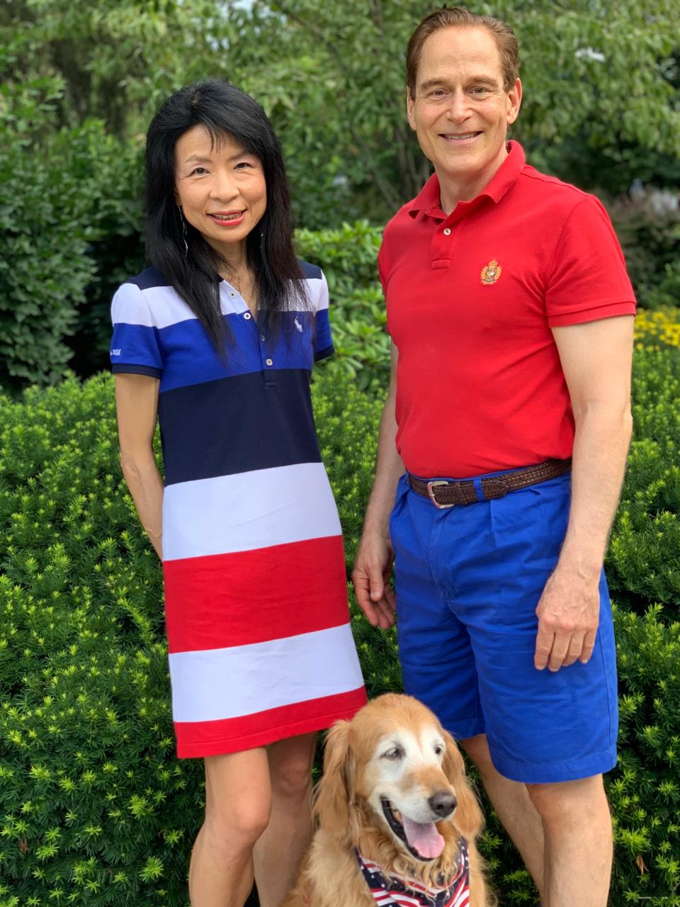 Dressed for the Fourth of July in 2021, Yuko and Dave pose for a photo with their golden retriever, Cassie.