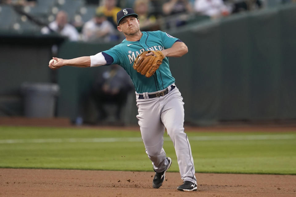 Seattle Mariners third baseman Kyle Seager throws out Oakland Athletics' Josh Harrison at first base during the first inning of a baseball game in Oakland, Calif., Monday, Sept. 20, 2021. (AP Photo/Jeff Chiu)