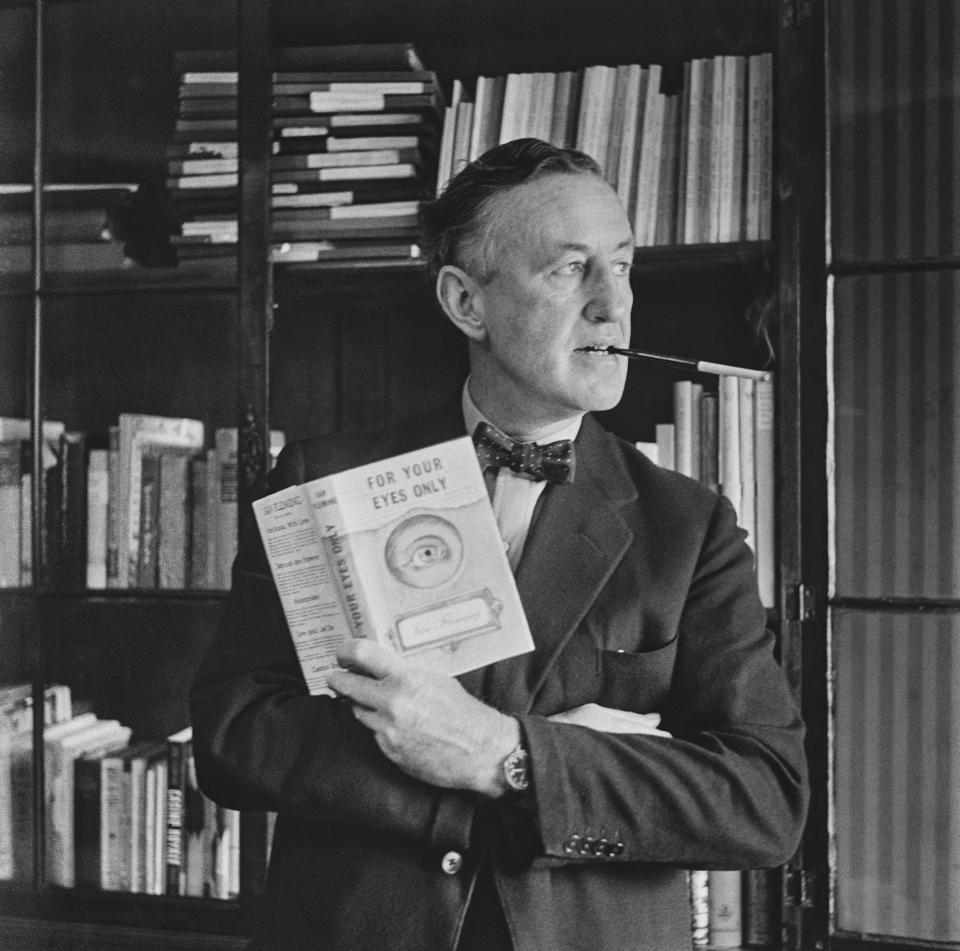 Author Ian Fleming (1908-1964) smoking in his study while holding a book of new 'James Bond' short stories called 'For Your Eyes Only', April 4th, 1960. (Photo by Evening Standard/Hulton Archive/Getty Images)