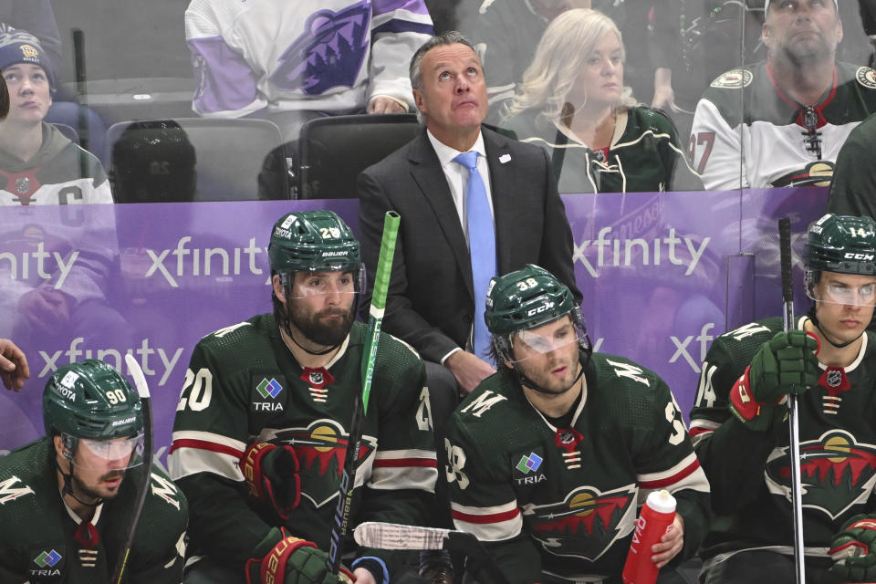 Minnesota Wild head coach Dean Evason, center top, checks the scoreboard during the third period of an NHL hockey game against the Dallas Stars, Sunday, Nov. 12, 2023, in St. Paul, Minn. (AP Photo/Craig Lassig)