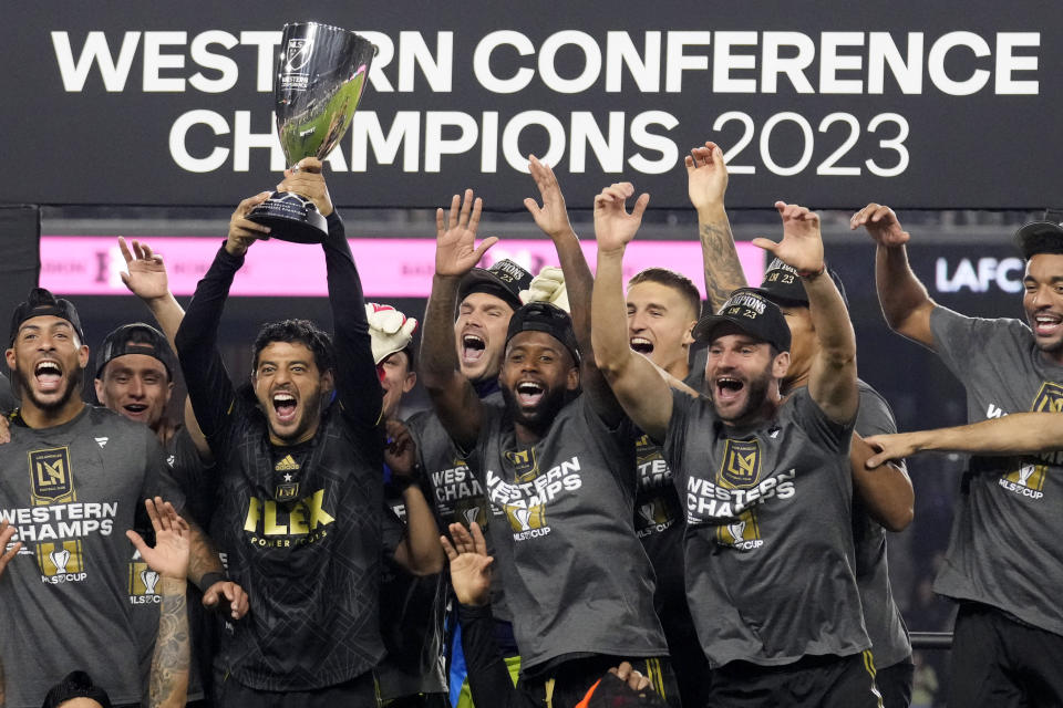 Los Angeles FC forward Carlos Vela, center left, holds the trophy after Los Angeles FC defeated Houston Dynamo 2-0 to win the MLS playoff Western Conference final soccer match Saturday, Dec. 2, 2023, in Los Angeles. (AP Photo/Marcio Jose Sanchez)