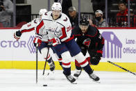 Washington Capitals' Lars Eller (20) moves the puck after taking it from Carolina Hurricanes' Vincent Trocheck (16) during the third period of an NHL hockey game in Raleigh, N.C., Sunday, Nov. 28, 2021. (AP Photo/Karl B DeBlaker)