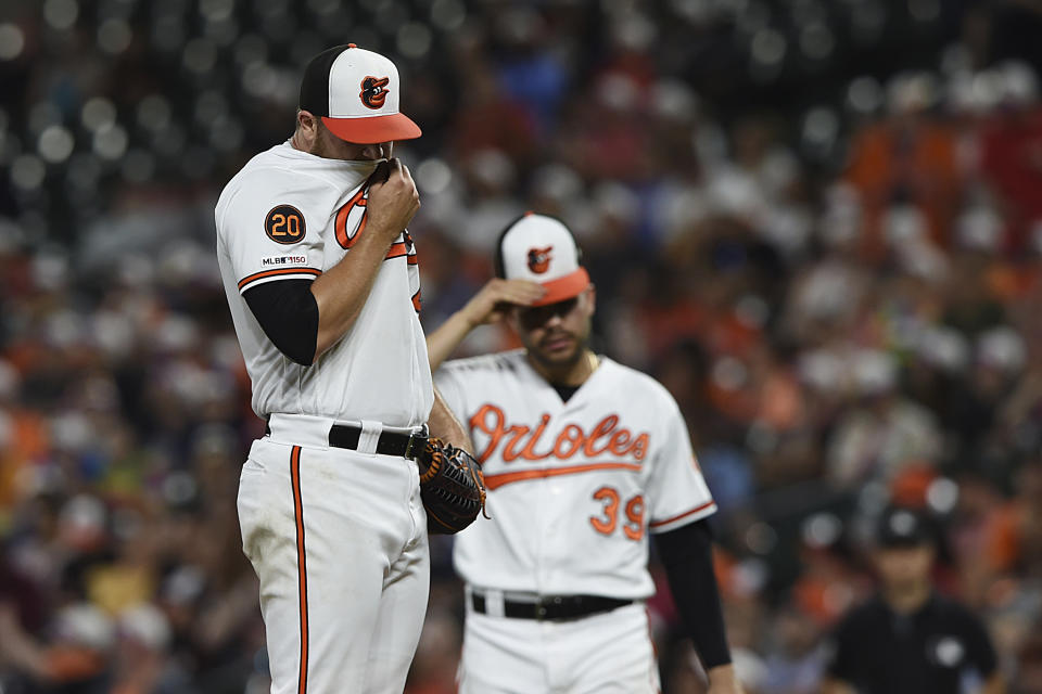 Baltimore Orioles pitcher David Hess, left, reacts after loading the bases with Toronto Blue Jays during the fifth inning of a baseball game Wednesday, June 12, 2019, in Baltimore. (AP Photo/Gail Burton)