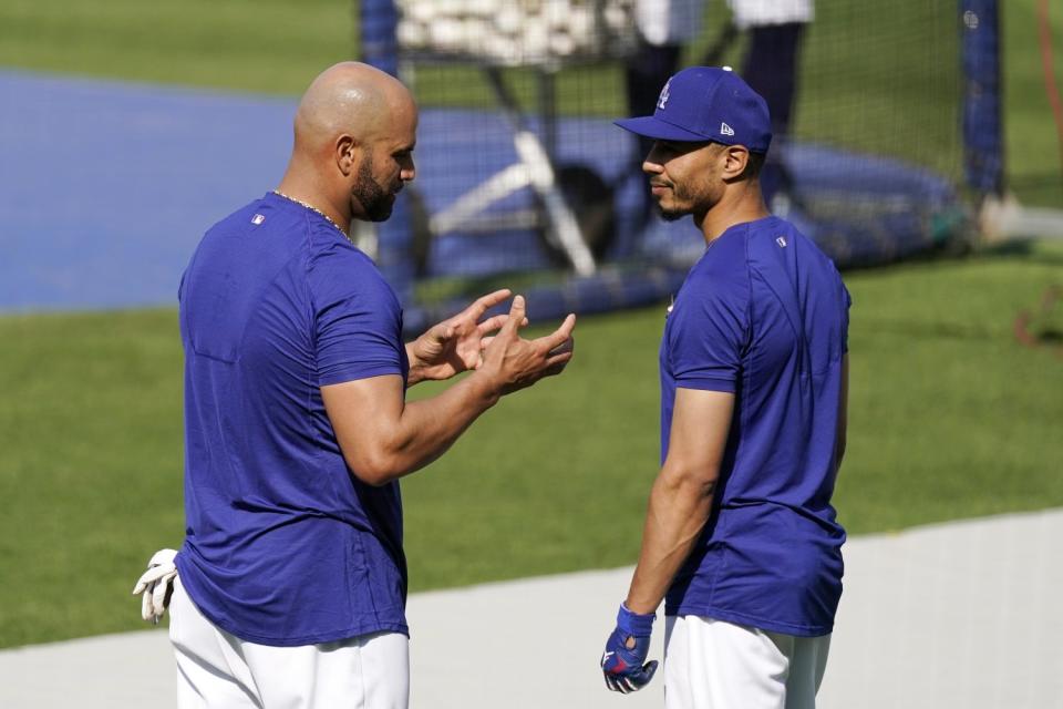 Dodgers first baseman Albert Pujols, left, speaks with right fielder Mookie Betts.