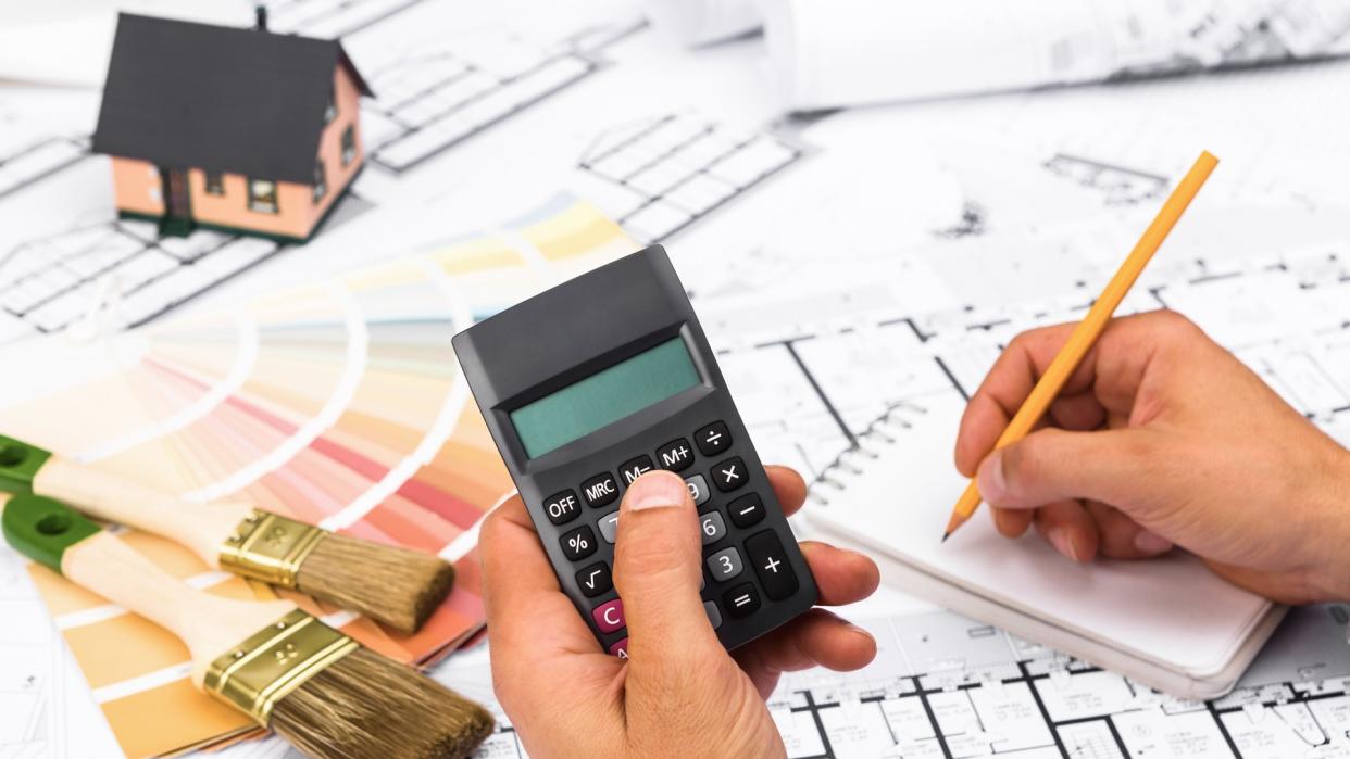 businessman working on accounts using a calculator and writing on notebook.