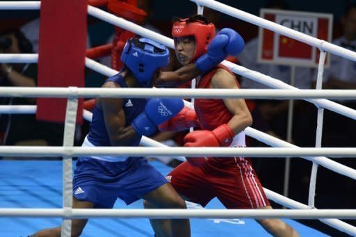 Ren Cancan of China (in red) defends against Nicola Adams of Great Britain (in blue) during the women's boxing Flyweight final of the 2012 London Olympic Games at the ExCel Arena August 9, 2012 in London. Nicola Adams defeated Cancan Ren to win gold