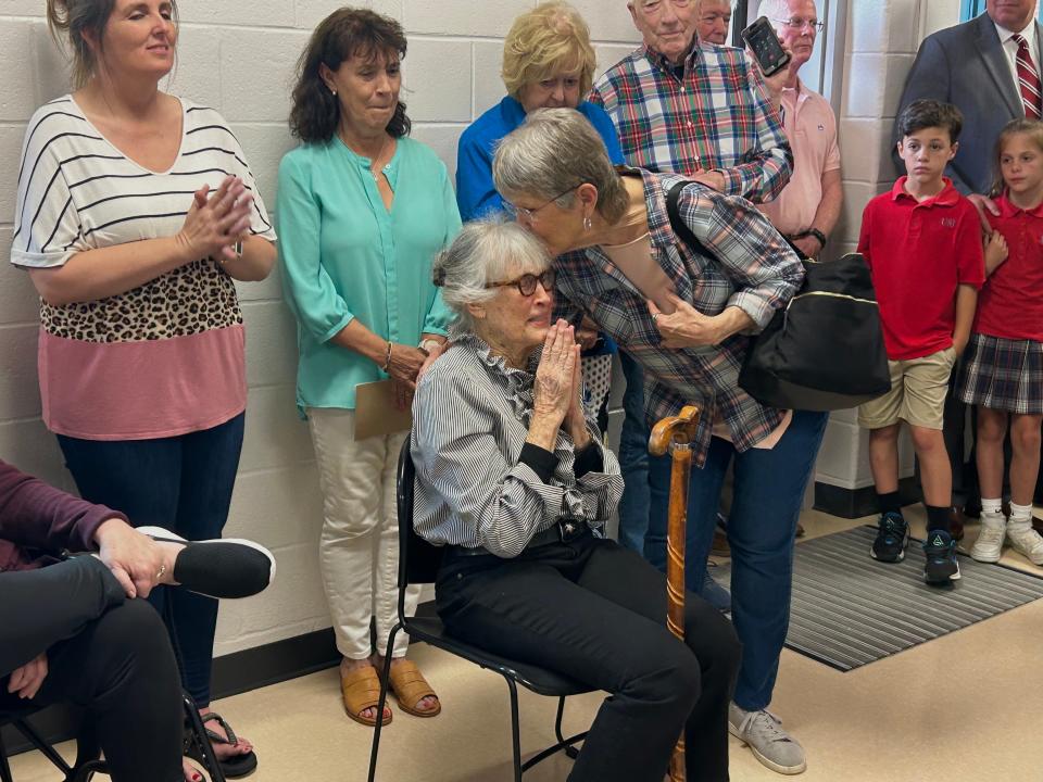 Cornelia Tiller (Ms. Happy) receives a kiss on the forehead from her friend at the dedication ceremony honoring Tiller's volunteer work at the Madison County Jail in Jackson, Tenn., on May 16, 2023.