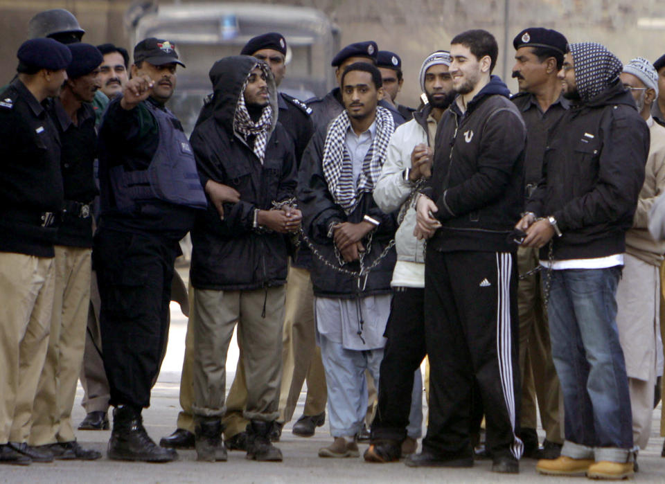 FILE - Detained American Muslims, center, including Ramy Zamzam, third from right in striped pants, are escorted by Pakistan police officers as they leave after appearing in court in Sargodha, Pakistan, Monday, Jan. 4, 2010. Zamzam, a northern Virginia man who traveled to Pakistan with four friends nearly 15 years ago seeking to engage in holy war who pleaded guilty Wednesday, April 26, 2023, to a terrorism charge, but he is likely to receive only a 1-day jail sentence. The guilty plea from Zamzam comes after he and his friends spent nearly 13 years in a Pakistani prison after their arrest there in 2009. (AP Photo/K.M. Chaudary, File)