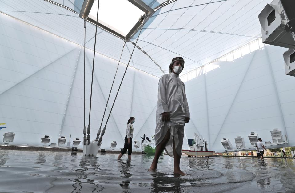 People enjoy walking in a pool of the Brazil Pavilion at the Dubai Expo 2020, in Dubai, United Arab Emirates, Sunday, Oct, 3, 2021. (AP Photo/Kamran Jebreili)