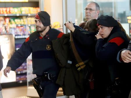 Family members of passengers killed in Germanwings plane crash are escorted by Regional Catalan Police officers as they arrive at Barcelona's El Prat airport March 24, 2015. REUTERS/Albert Gea