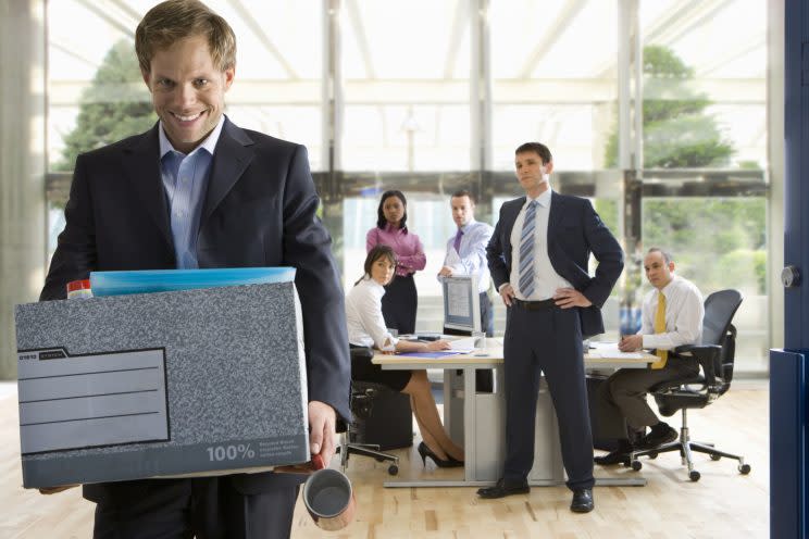 Business people watching smiling businessman leave office with box of belongings