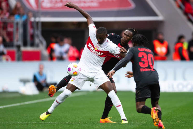 Leverkusen's Odilon Kossounou (C) and Stuttgart's Serhou Guirassy (L) battle for the ball during the German Bundesliga soccer match between Bayer Leverkusen and VfB Stuttgart at the BayArena. Marius Becker/dpa