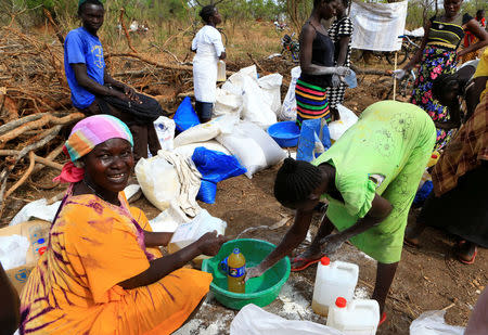 South Sudanese refugees displaced by fighting, distribute cooking oil they received from World Food Programme (WFP) in Imvepi settlement in Arua district, northern Uganda, April 4, 2017. Picture taken April 4, 2017. REUTERS/James Akena