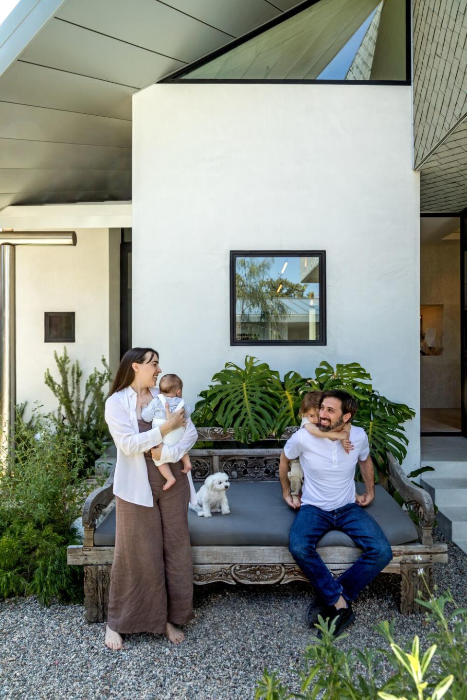 Parents with two children and a dog in a shaded alcove.