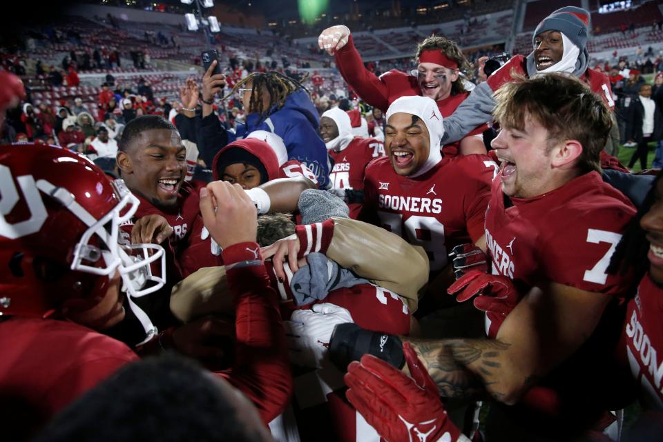 Nov 19, 2022; Norman, Oklahoma, USA;  Oklahoma players react after Michael Turk (37) proposed to OU softball player Grace Lyons following the Bedlam college football game between the University of Oklahoma Sooners (OU) and the Oklahoma State University Cowboys (OSU) at Gaylord Family-Oklahoma Memorial Stadium. Mandatory Credit: Sarah Phipps-USA TODAY Sports