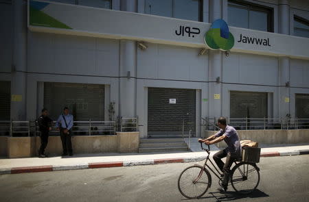 Palestinian policemen loyal to Hamas stand guard outside closed Jawwal company headquarters in Gaza City June 30, 2015. REUTERS/Mohammed Salem