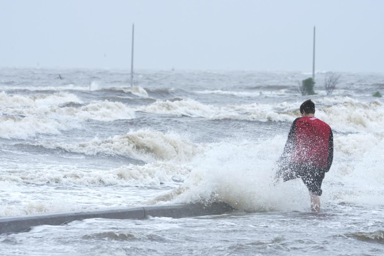 A person watches the wind and waves at the Gulfport Municipal Marina as outer bands of Hurricane Ida arrive on Sunday, Aug. 29, 2021, in Gulfport, Miss.