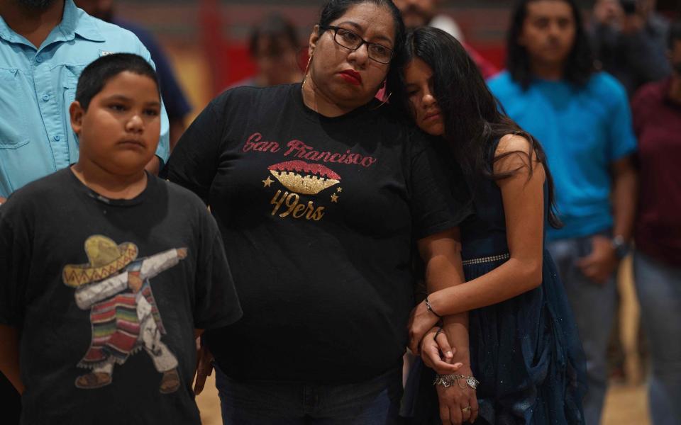 People mourn as they attend a vigil for the victims of the mass shooting at Robb Elementary School in Uvalde - AFP