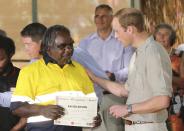 Britain's Prince William presents an achievement certificate to Xavier Kitson during a visit to the National Indigenous Training Academy at Yulara, near Uluru, Australia, Tuesday, April 22, 2014. The Duke and Duchess of Cambridge are on a three-week tour of Australia and New Zealand, the first official trip overseas with their son, Prince George. (AP Photo/Rob Griffith)