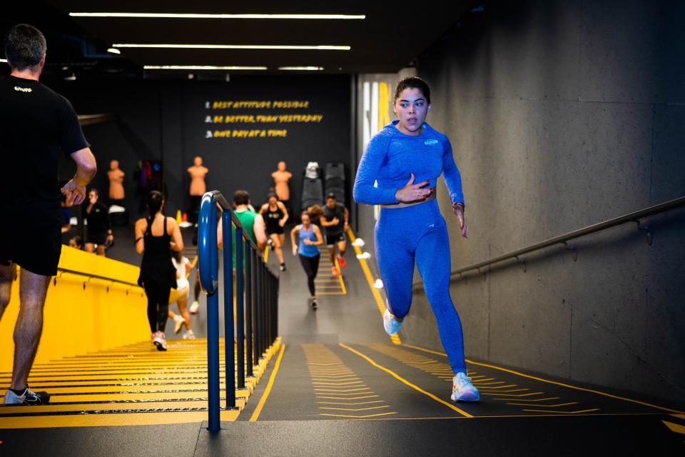 A group of athletes run up a ramp in a gym