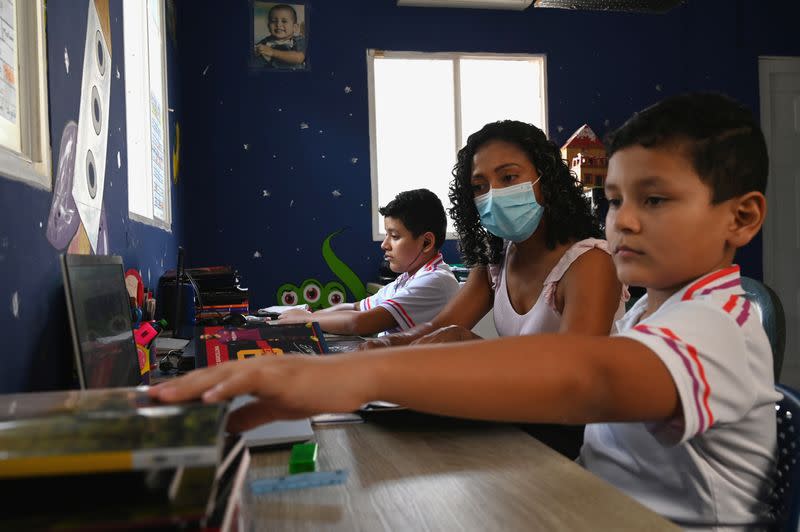 Claudia Patricia Fortich, widow of late oil tanker captain Jaime Herrera Orozco who was murdered on his ship while anchored off Venezuela, helps her children while they study at home, in Cartagena